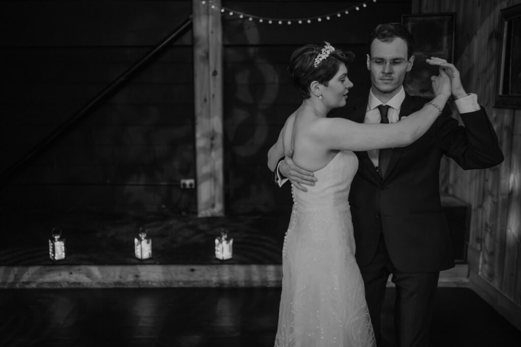 Black and white image of Bride dancing with her brother during wedding. 