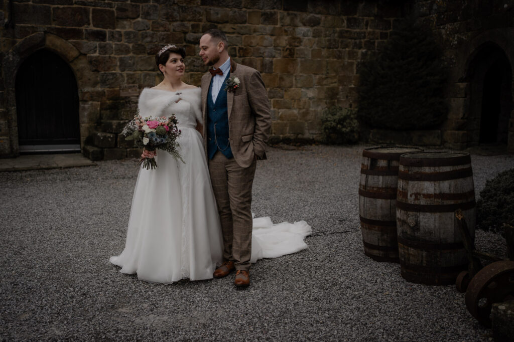 Couple holding hand in hand outside barn wedding.