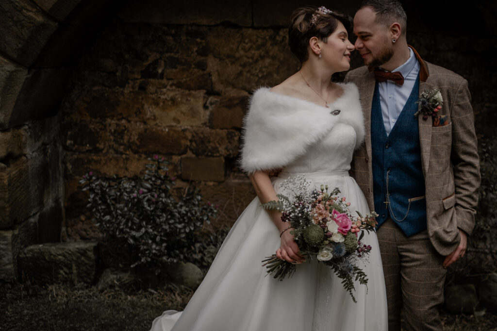 Couples portrait outside during moody winter wedding. 